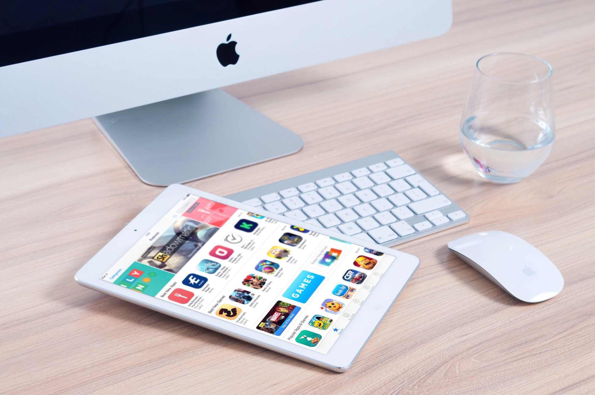 Photo of ipad laying across computer keyboard and near mouse all Apple products