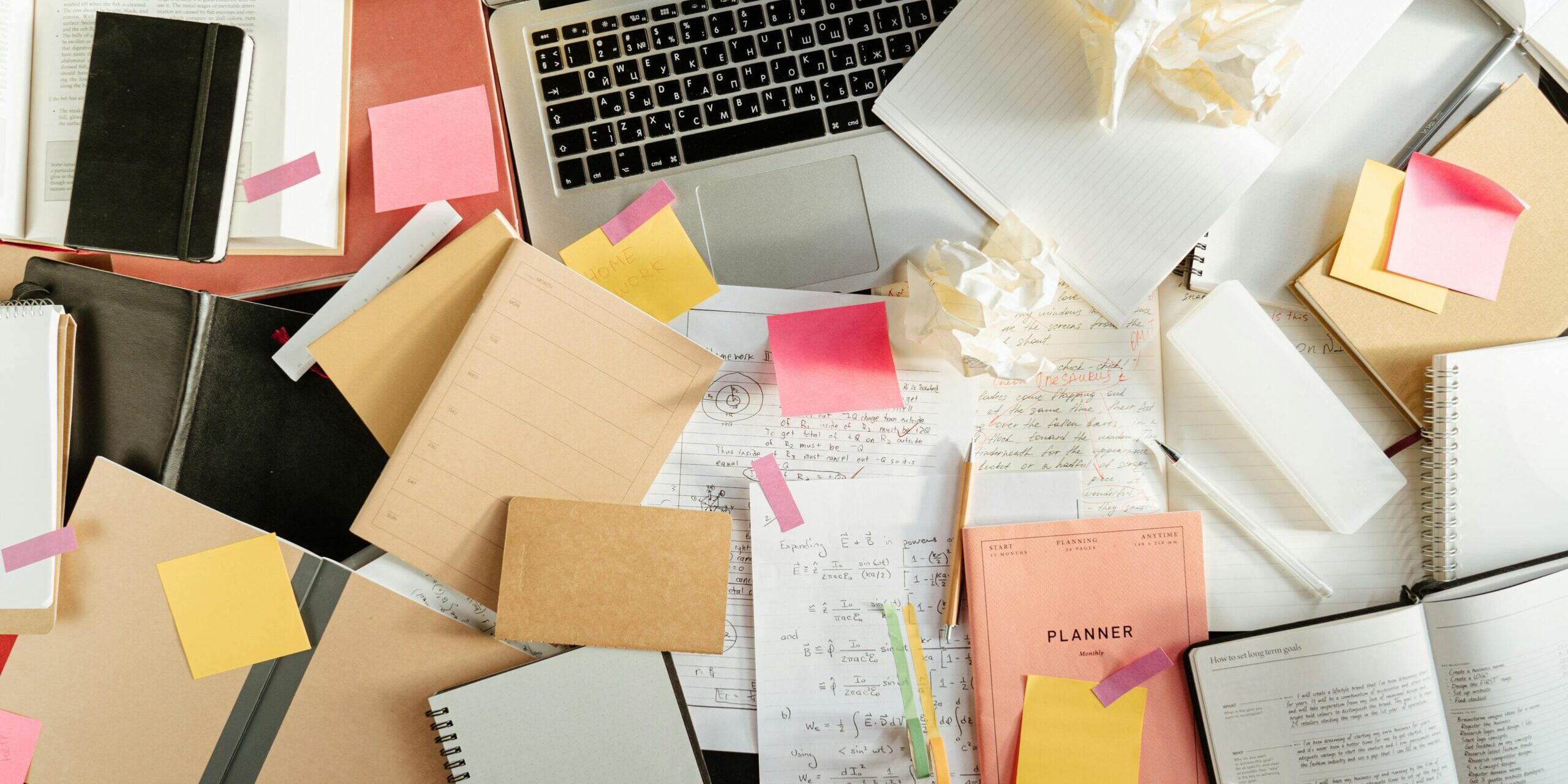Stock photo from pexels Cottonbro, messy desk with lots of papers and books, some crumpled papers.